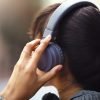 woman with headphones in city, back view and listen to music, freedom and technology outdoor. mockup space, podcast or radio streaming with female person in urban street and audio playlist