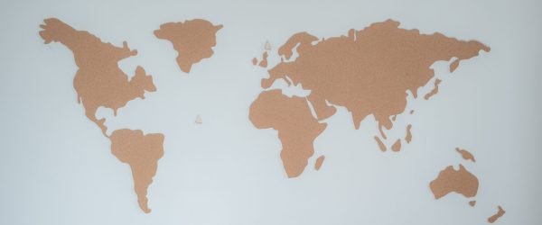A minimalist cork board world map displayed on a white wall provides modern decor inspiration.